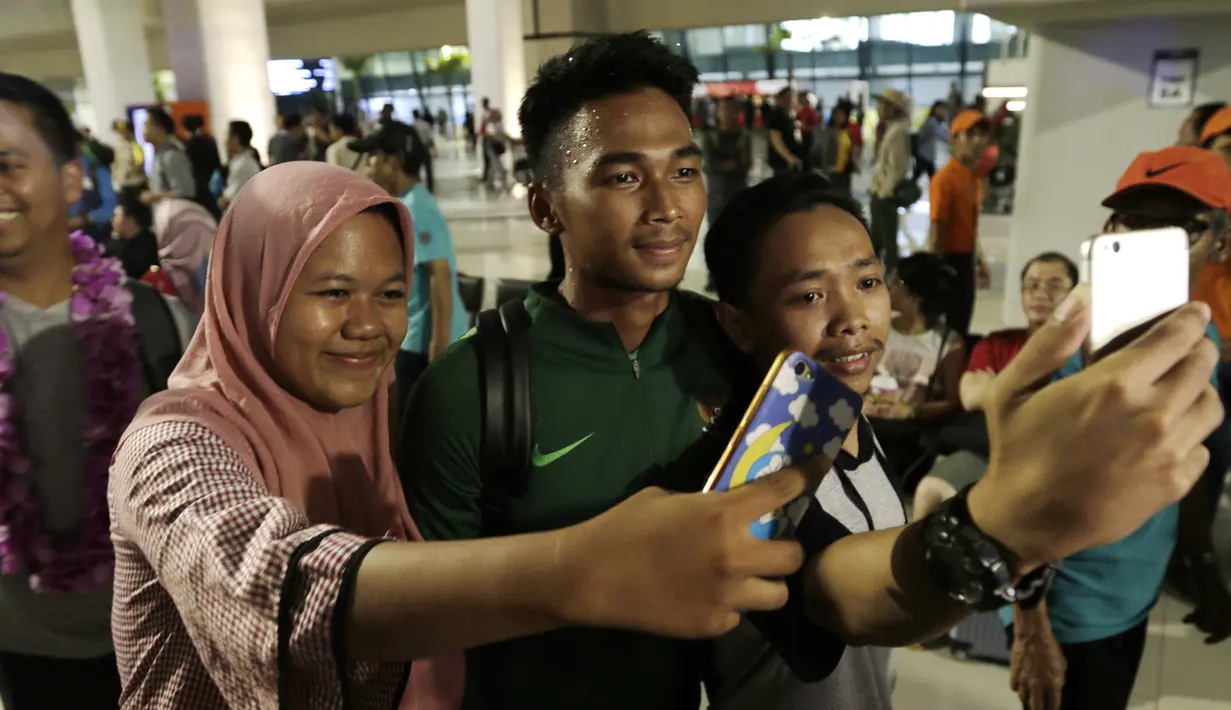Warga mengajak selfie pemain Timnas Indonesia, Bagas Adi, usai menjadi juara Piala AFF U-22 2019 di Bandara Soetta, Tanggerang, Rabu (27/2). Timnas Indonesia mendapatkan bonus sebesar 2,1 milliar rupiah dari Kemenpora. (Bola.com/Yoppy Renato)