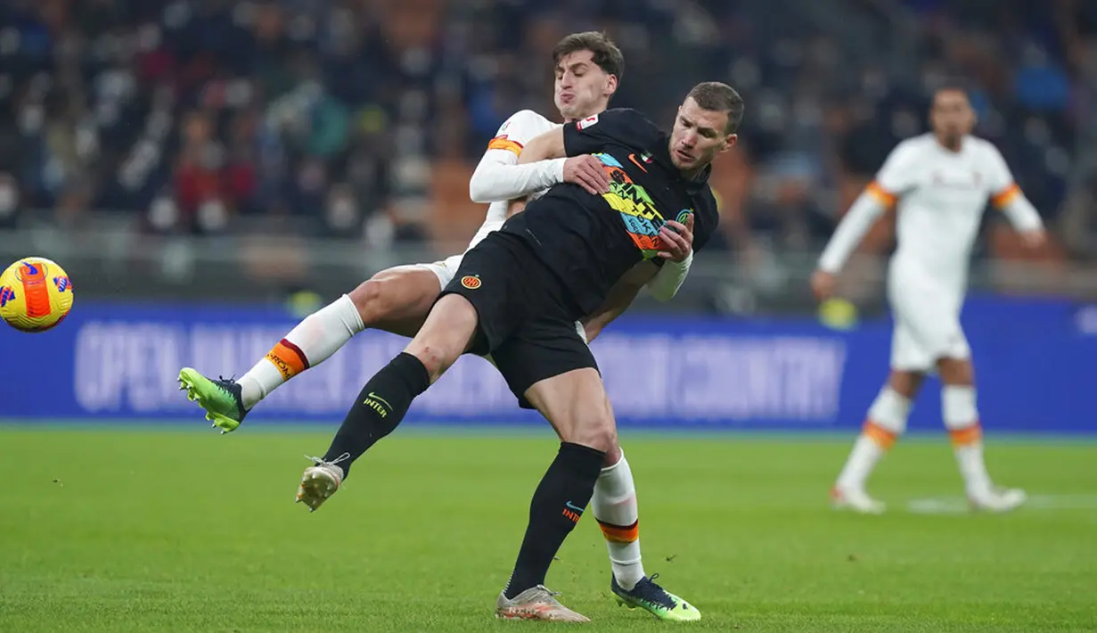 Pemain Inter Milan Edin Dzeko (kanan) berebut bola dengan pemain AS Roma Marash Kumbulla (kiri) pada pertandingan sepak bola Coppa Italia di Stadion San Siro, Milan, Italia, 8 Februari 2022. Inter Milan menang 2-0. (Spada/LaPresse via AP)
