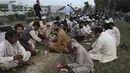 Orang-orang berbuka puasa selama bulan suci Ramadhan di pinggir jalan, di Islamabad, Pakistan, Selasa, 5 April 2022. Umat Muslim di seluruh dunia menjalankan Ramadhan, di mana mereka menahan diri dari makan, minum, merokok dan seks dari fajar hingga senja. (AP Photo/Rahmat Gul)