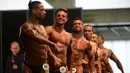 Para peserta pria bersiap tampil dalam kompetisi binaraga Mr. Olympia Amateur South America di Medellin, Kolombia (18/2). (AFP Photo / Raul Arboleda)