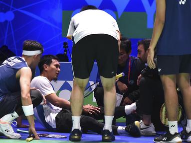 Pebulutangkis Indonesia, Mohammad Ahsan (kedua kiri) mengalami cedera di lutut kiri saat melawan ganda putra Indonesia, Fajar Alfian/Muhammad Rian Ardianto dalam pertandingan final All England 2023yang berlangsung di Birmingham Arena, Minggu (19/3/2023). Fajar/Rian berhasil mengalahkan senior mereka, Mohammad Ahsan/Hendra Setiawan, dua gim langsung 21-17 dan 21-14. (AP Photo/Rui Vieira)