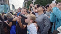 Masyarakat melihat aksi atlet panjat tebing 'free solo' asal Amerika, Alex Honnold saat memanjat gedung Taipei 101 tanpa tali pengaman di Taipei, Minggu (25/01/2026). (AP Photo/Chiang Ying-ying)