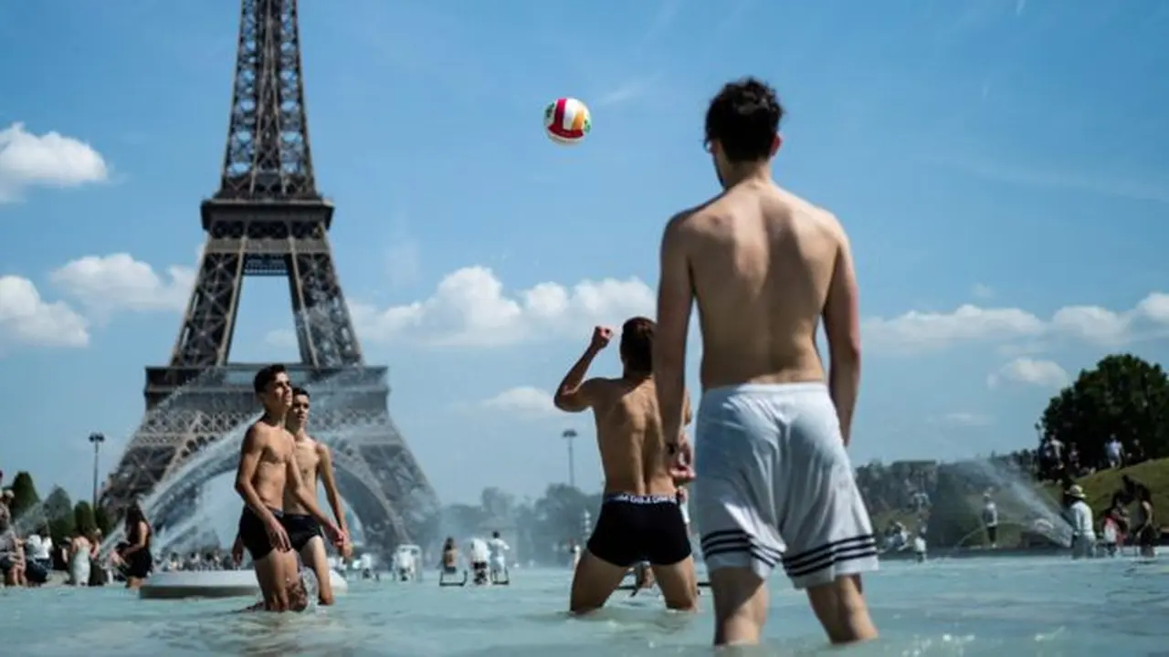 warga Paris mendinginkan badan di kolam di depan Menara Eiffel (AFP Photo)
