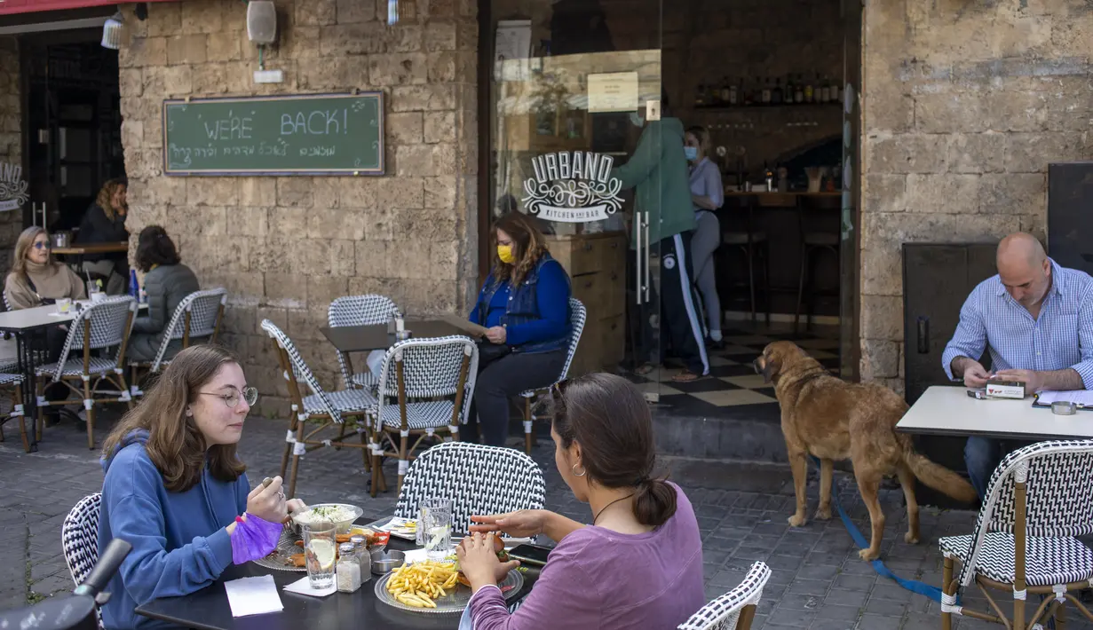 Orang-orang makan di restoran setelah pembatasan virus corona dilonggarkan di Tel Aviv, Minggu (7/3/2021). Israel membuka kembali sebagian besar ekonominya sebagai bagian dari fase terakhir pencabutan kebijakan lockdown yang berlaku sejak September tahun lalu. (AP Photo/Ariel Schalit)