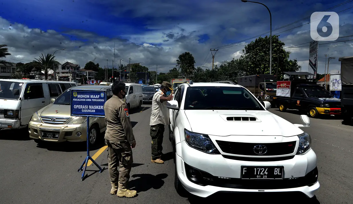 Petugas gabungan melakukan pemeriksaan surat rapid test antigen bagi wisatawan yang masuk ke wilayah Puncak di Gadog, Bogor, Kamis (24/12/2020). Wisatawan yang tidak memiliki surat keterangan rapid test antingen disuruh putar balik. (merdeka.com/Arie Basuki)