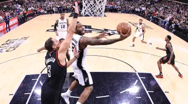 Pemain Spurs, Kawhi Leonard (2) berusaha memasukan bola ke ring di gim kelima semifinal wilayah barat Playoffs NBA 2017 di AT&T Center, San Antonio, Texas (9/5). Spurs mengalahkan Rockets 110-107 lewat overtime. (Ronald Martinez/Getty Images/AFP)