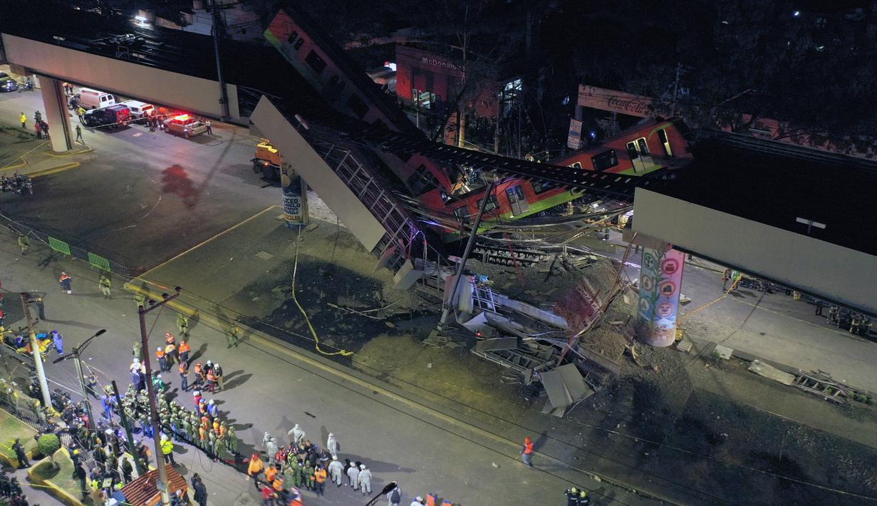 Petugas penyelamat berkumpul di lokasi kecelakaan setelah jembatan layang untuk kereta metro ambruk di Mexico City, Senin (3/5/2021). Kru medis dan petugas pemadam sudah berada di lokasi untuk memulai evakuasi mencari korban yang mungkin terperangkap di reruntuhan. (Pedro PARDO/AFP)
