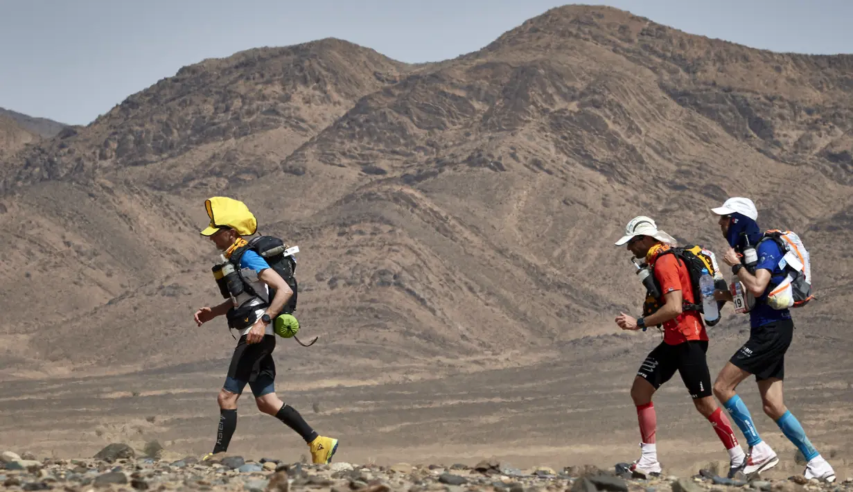 Peserta mengikuti perlombaan Marathon des Sables ke-32 tahap ketiga di Gurun Sahara, sebelah selatan Maroko, Selasa (11/4). Kompetisi yang awalnya hanya diikuti oleh 23 peserta ini kini telah mendunia dan menjadi daya tarik. (JEAN-PHILIPPE KSIAZEK/AFP)