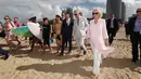 Pangeran Charles bersama istrinya, Duchess of Cornwall Camilla berjalan di atas pasir pantai saat mengunjungi Broadbeach di Gold Coast, Australia, Kamis (5/4). Istri Pangeran Charles itu terlihat berjalan tanpa alas kaki. (AFP PHOTO/POOL/Mark Metcalfe)