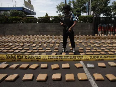 Petugas berjaga saat rilis barang bukti ganja sebanyak 1.300 paket dengan total 1,3 ton di Polres Jakarta Barat, Kamis (4/1). Polres Metro Jakbar berhasil menghentikan penyelundupan 1,3 ton ganja dari Provinsi Aceh ke Jakarta. (Liputan6.com/Arya Manggala)