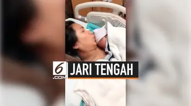 Aksi lucu dilakukan seorang bayi yang baru lahir saat akan dipeluk ibunya pertama kali. Ia malah menunjukkan jari tengah pada ayahnya sendiri.