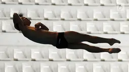 Aksi seorang atlet loncat indah saat bersaing dalam babak penyisihan nomor springboard 3m putra Asian Games 2018 di arena Aquatic Centre, GBK, Jakarta, Jumat (31/8).(merdeka/Imam Buhori)