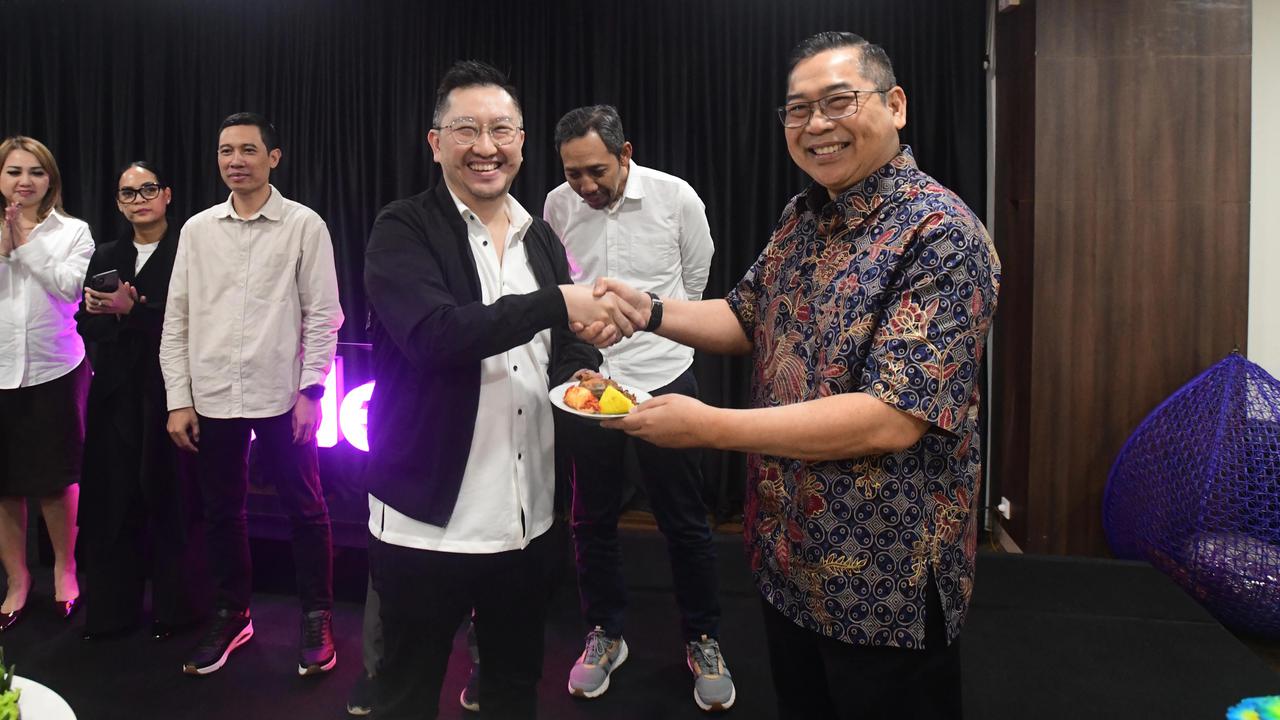 CEO Kapanlagi Universi (KLY) Danny Purnomo (kanan) menyerahkan nasi tumpeng kepada Corporate Secretary SCMA, Gilang Iskandar saat ulang tahun ke 14 Merdeka.com di Gedung KLY, Jakarta, Senin (23/02/2026)