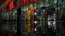 Orang-orang melewati pertunjukan cahaya malam di Lyon, Prancis tengah, Rabu (8/12/2021). Jutaan orang diperkirakan akan menghadiri acara Festival of Lights selama empat hari di kota itu. (AP Photo/Laurent Cipriani)