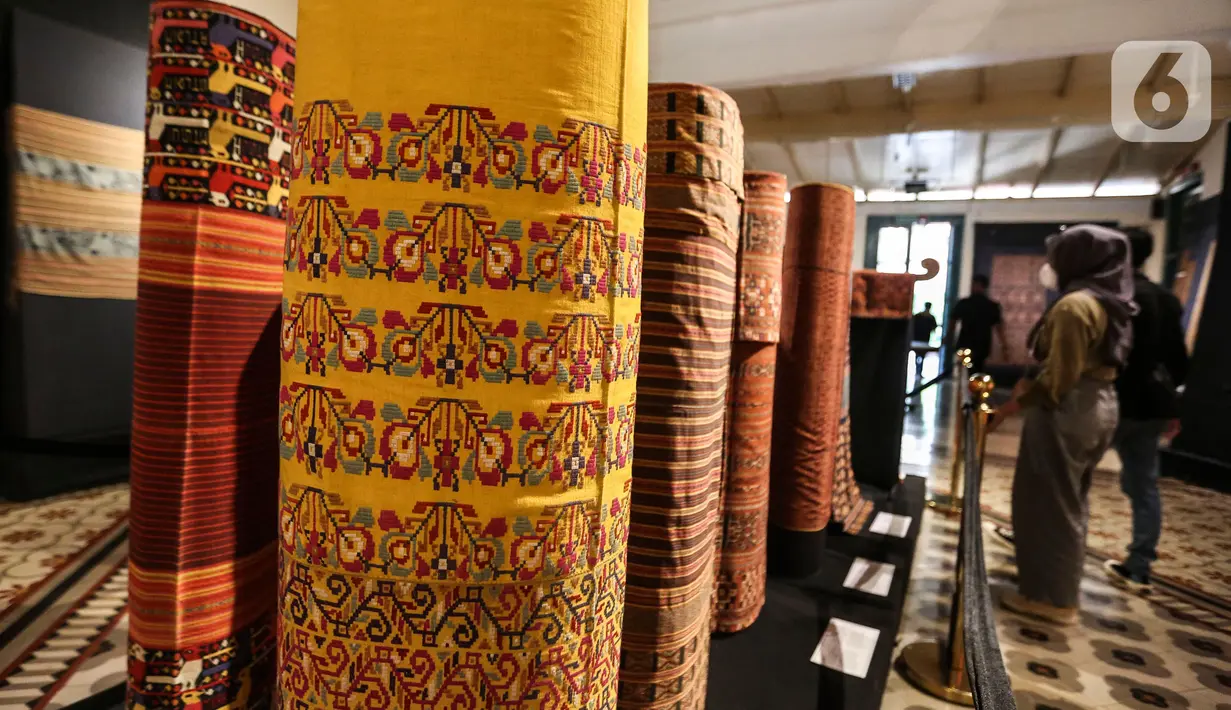 Pengunjung melihat kain tenun di pameran tenun bertajuk "Nuansa Kemilau Wastra Tenun Indonesia" di Museum Tekstil, Jakarta, Rabu (20/7/2022). Pameran dalam rangka memperingati HUT ke - 77 RI ini berlangsung hingga 31 agustus 2022 mendatang dan menampilkan kerajinan tenun dari Sumatera, Sulawesi, dan Timor. (Liputan6.com/Johan Tallo)