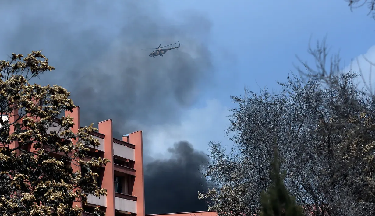 Helikopter militer Afghanistan terbang di atas rumah sakit militer terbesar di Kabul setelah insiden baku tembak di dalam gedung, Rabu (8/3). Sejumlah pria bersenjata memakai seragam dokter menyerbu RS tersebut. (AP Photos/Massoud Hossaini)