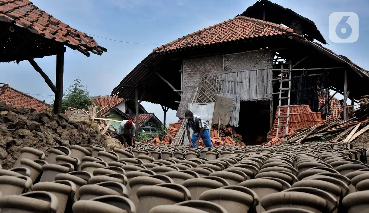 Pekerja menjemur genteng di pabrik genteng rumahan (Jebor) Mutiara Putra, Desa Burujul Wetan, Kecamatan Jatiwangi, Kabupaten Majalengka, Minggu (30/1/2022). Sejak tahun 70-an, Kecamatan Jatiwangi terkenal dengan sentra genteng yang hasil produksinya kualitas terbaik. (merdeka.com/Iqbal S. Nugroho)