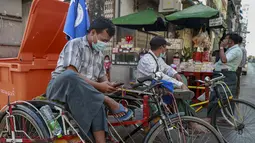 Seorang pengemudi becak memeriksa ponselnya di Yangon, Myanmar (4/2/2021).   Beberapa warga Myanmar di forum media sosial Reddit melaporkan sudah tidak bisa mengakses Facebook di ponsel mereka. (AP Photo)