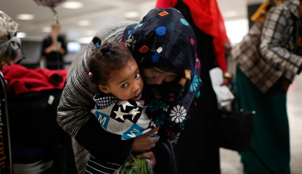 Zahra Warsma memeluk cucunya setelah berpergian bersama sang ibu dari Somalia, setibanya di Bandara Dulles, Washington, Senin (6/2). Sejumlah warga muslim sempat tidak dapat masuk AS akibat kebijakan imigrasi Donald Trump. (Win McNamee/Getty Images/AFP)