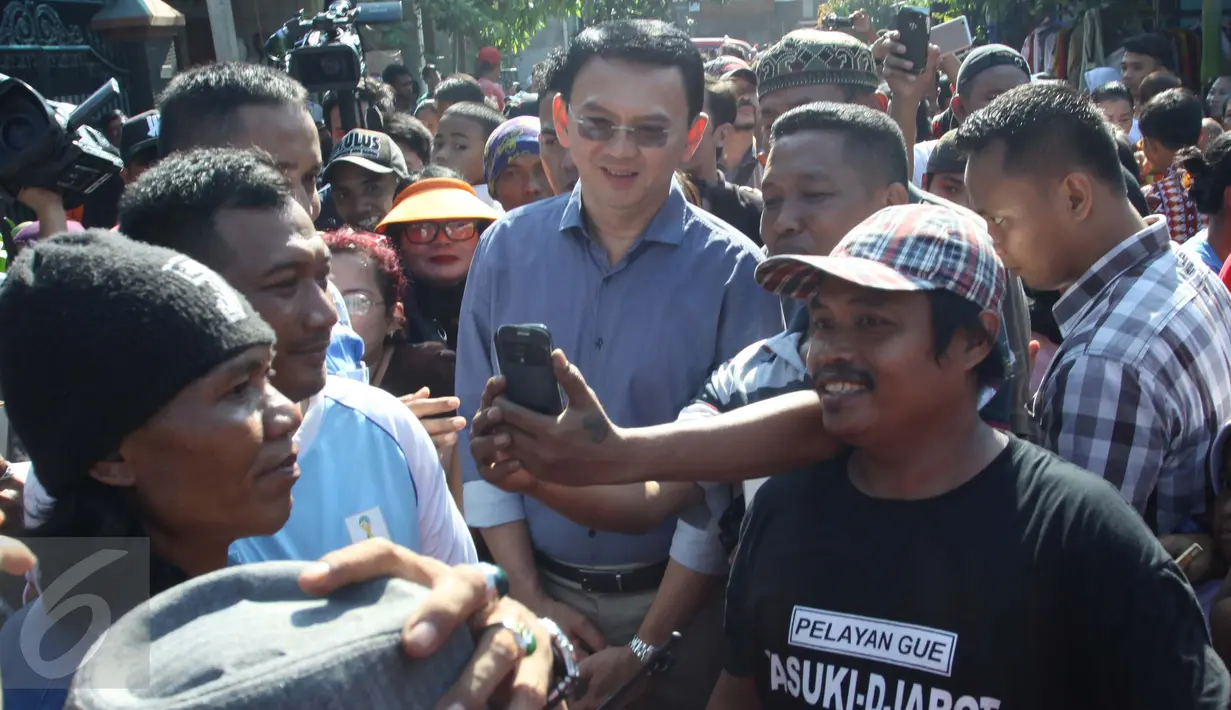 Warga berebut foto dengan Cagub DKI Jakarta Basuki T Purnama (Ahok) saat kampanye blusukan di kawasan Koja, Jakarta, Jumat (24/3). Ahok mengunjungi warga lansia yang sedang sakit dan menawarkan untuk menunaikan ibadah haji. (Liputan6.com/Gempur M Surya)