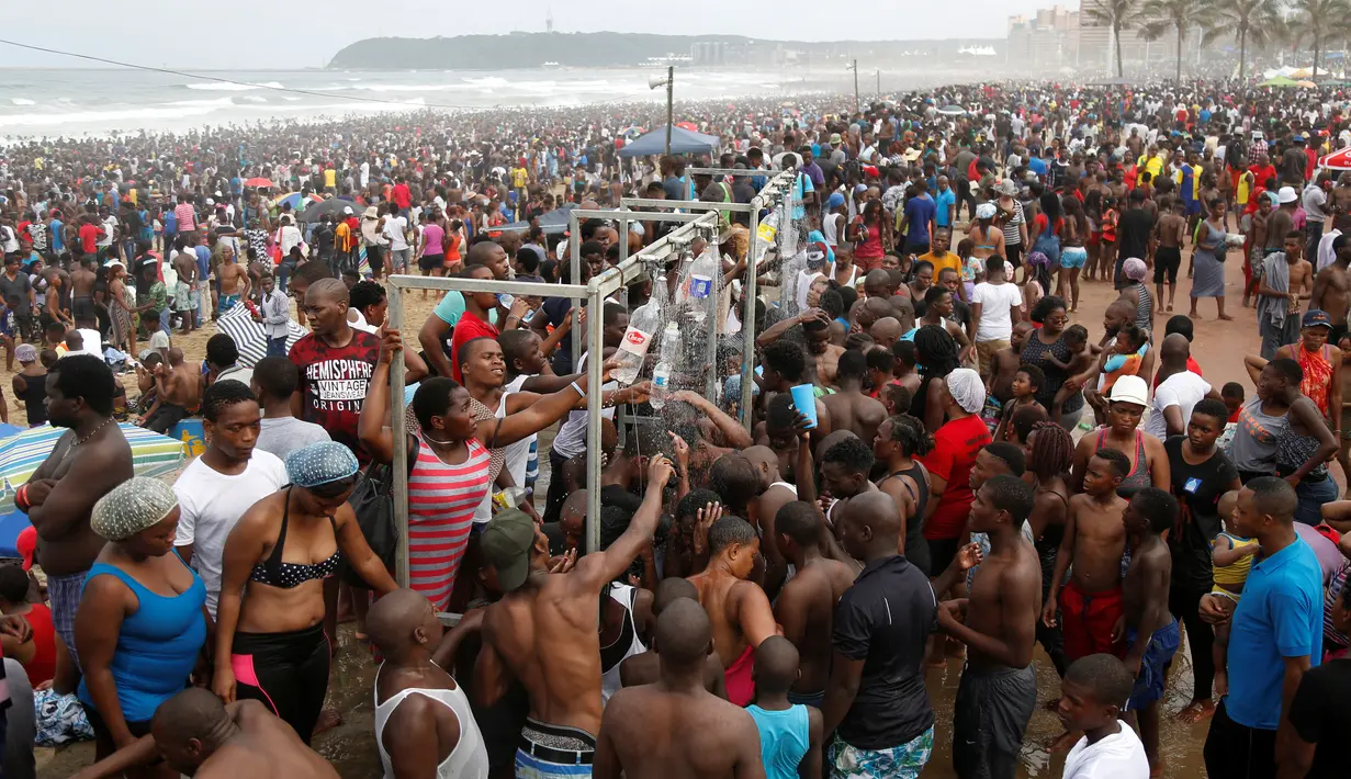 Pengunjung antre untuk membilas tubuh mereka saat liburan awal Tahun Baru 2017 di sebuah pantai di Durban, Afrika Selatan (1/1). (REUTERS/Rogan Ward)