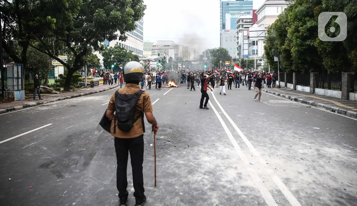 Anggota brimob memukul mundur massa aksi di kawasan Tanah Abang, Jakarta, Selasa (13/10/2020). Hingga menjelang magribh massa masih melakukan perlawan di kawasaan tersebut. (Liputan6.com/Faizal Fanani)