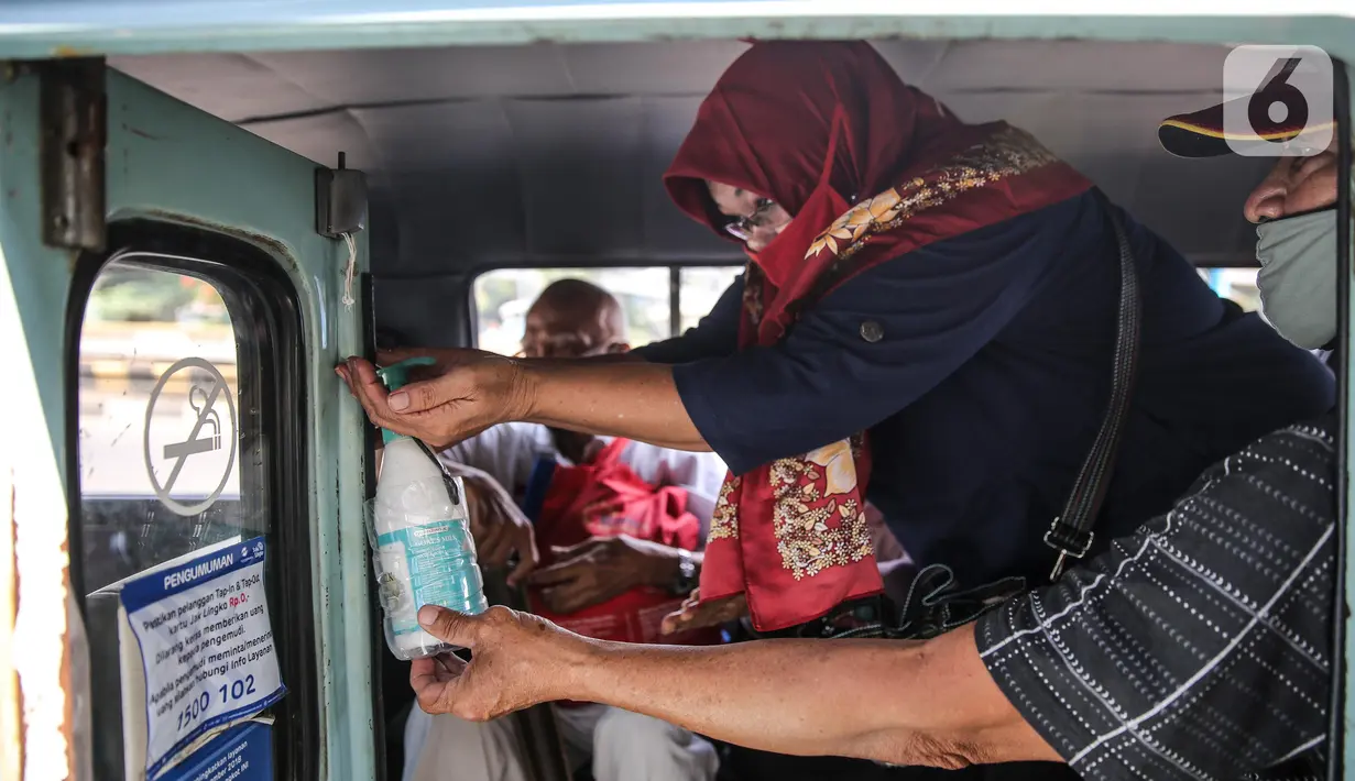 Penumpang menggunakan cairan pembersih tangan saat menaiki angkutan umum Jak Lingko di kawasan Cawang, Jakarta, Senin (6/7/2020). Pada perpanjangan masa PSBB transisi, angkutan umum sudah mulai beroperasi kembali dengan menerapkan protokol Kesehatan Covid-19. (Liputan6.com/Faizal Fanani)
