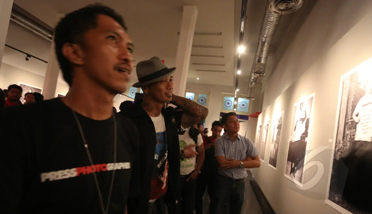 Drummer grup musik Superman Is Dead, Jrx (kedua kiri) saat melihat koleksi pameran fotografi "Laut Luka Blues" di Jakarta, Jumat (22/5/2015). Tema foto mengangkat fenomena pemuda Bali saat menyuarakan pendapat isu lingkungan. (Liputan6.com/Faizal Fanani)