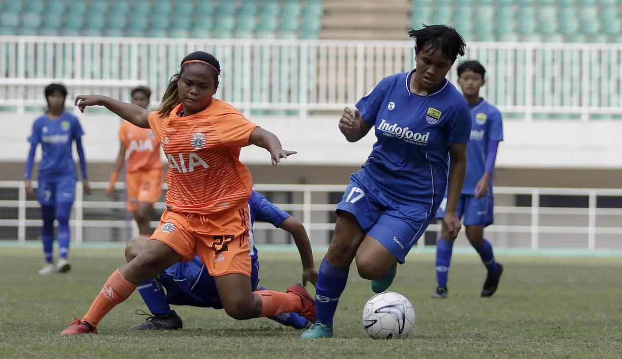 Gelandang Persija Jakarta Putri, Tiara Mahardika, berebut bola dengan gelandang Persib Bandung, Intan Nuraini, pada laga lanjutan Liga 1 Putri 2019 di Stadion Pakansari, Bogor, Kamis (7/11). Persib Putri menang 2-1 atas Persija Putri. (Bola.com/Yoppy Renato)