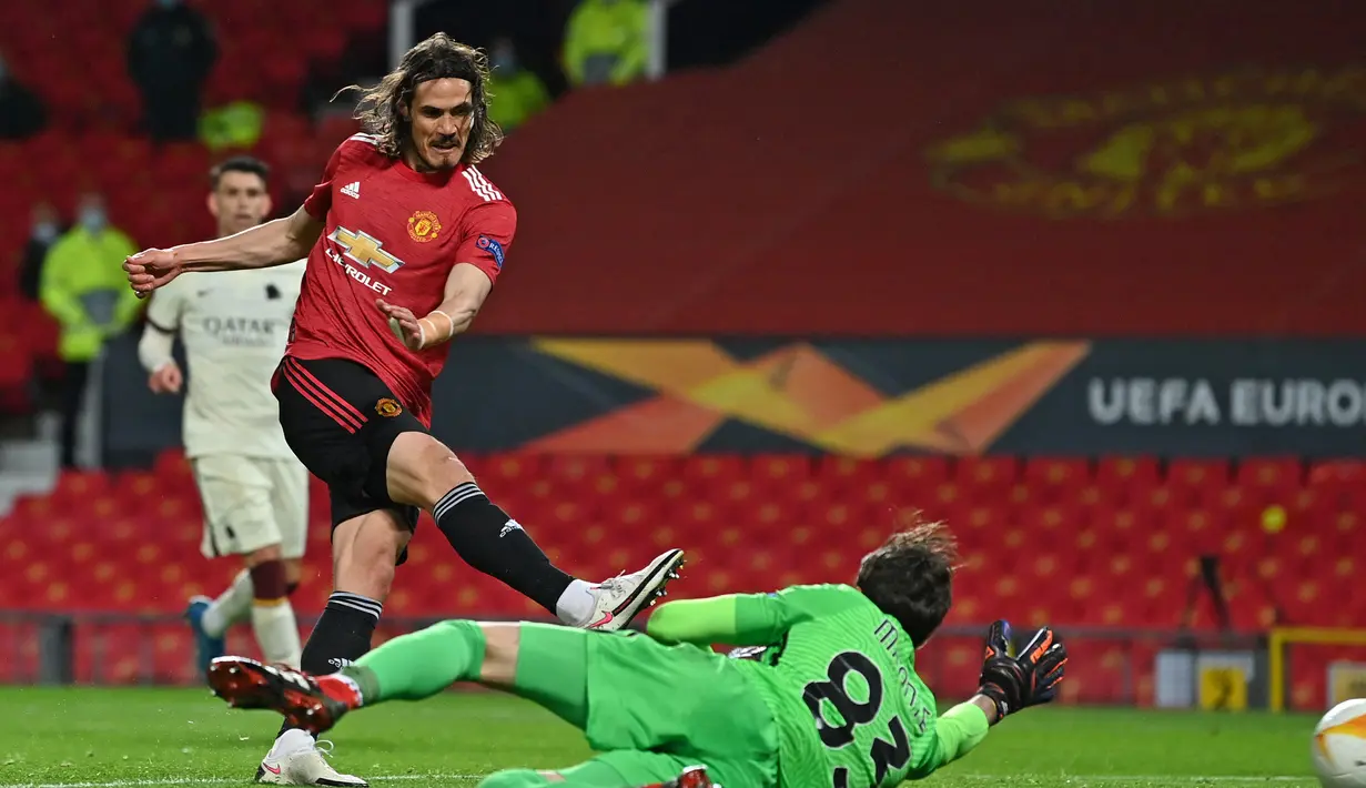 Striker Manchester United, Edinson Cavani (kiri) mencetak gol ketiga timnya ke gawang AS Roma dalam laga leg pertama semifinal Liga Europa 2020/2021 di Old Trafford Stadium, Manchester, Kamis (29/4/2021). Manchester United menang 6-2 atas AS Roma. (AFP/Paul Ellis)