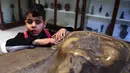 Seorang anak penyandang tunanetra menyentuh sebuah artefak di Museum Mesir di Kairo, Mesir (13/1/2020). Museum ini adalah rumah bagi koleksi antik bangsa Mesir kuno dan memiliki 120.000 koleksi. (Xinhua/Ahmed Gomaa)