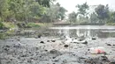 Sampah terlihat di dasar danau yang mengalami kekeringan di Taman Cempaka, Cipayung, Jakarta Timur, Minggu (7/7/2019). Danau buatan ini mengalami kekeringan akibat musim kemarau yang melanda sejak beberapa bulan terakhir. (merdeka.com/Iqbal S Nugroho)