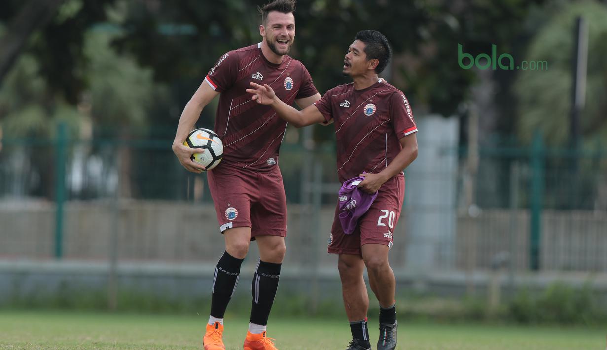 Pemain Persija Jakarta, Marko Simic (kiri) dan Bambang Pamungkas bercengkrama saat sesi latihan jelang Piala AFC 2018 di Lapangan ABC, Senayan, Jakarta, (13/3/2018). Persija akan melawan Song Lam Nghe An FC. (Bola.com/Nick Hanoatubun)