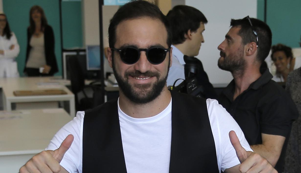 Penyerang baru Juventus, Gonzalo Higuain menyapa awak media saat tiba di Juventus Medical Center, Italia (27/7). Mantan pemain Napoli ini dikontrak Juve selama lima tahun dengan gaji delapan juta euro per musim. (AFP PHOTO/MARCO BERTORELLO)