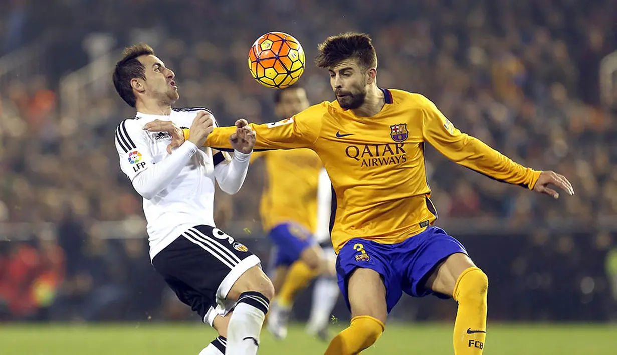 Striker Valencia, Paco Alcacer, berebut bola dengan bek Barcelona, Gerard Pique, pada laga La Liga Spanyol di Stadion Mestalla, Spanyol, Sabtu (5/12/2015). (EPA/Kai Foersterling)