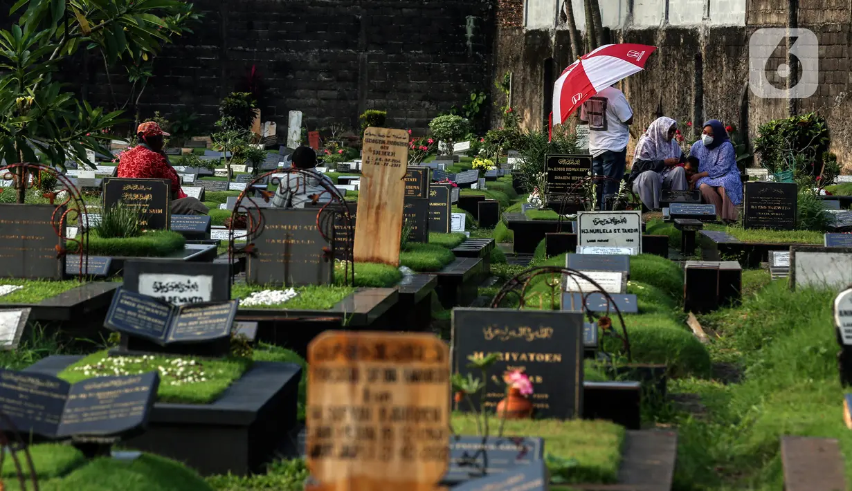 Sejumlah warga berziarah di makam keluarganya di Tempat Pemakaman Umum (TPU) Tanah Kusir, Jakarta, Selasa (29/3/2022). TPU setempat semakin banyak dikunjungi warga yang melakukan tradisi ziarah kubur menjelang Ramadhan. (Liputan6.com/Johan Tallo)