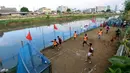 Warga bermain dalam kompetisi sepak bola di pinggir Kali Banjir Kanal Barat, Jakarta, Sabtu (5/11). Minimnya sarana bermain sepak bola mengakibatkan warga terpaksa memanfaatkan lahan di pinggir kali tersebut untuk bermain. (Liputan6.com/Johan Tallo)