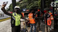 Petugas memotret warga pelanggar Pembatasan Sosial Berskala Besar (PSBB) yang terjaring razia masker di wilayah Tanah Abang, Jakarta, Senin (14/9/2020). Razia tersebut guna menekan kasus penyebaran COVID-19 di Jakarta pada masa PSBB. (Liputan6.com/Johan Tallo)