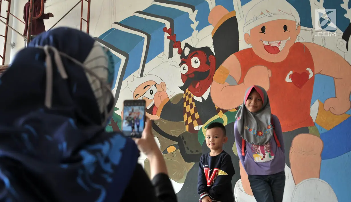 Anak-anak berpose di depan mural Wajah Baru Jakarta di terowongan Jalan Kendal, Jakarta, Kamis (20/6/2019).  Mural tersebut dibuat dalam rangka menyambut HUT ke-492 DKI Jakarta sekaligus mempercantik lingkungan. (merdeka.com/Iqbal S. Nugroho)