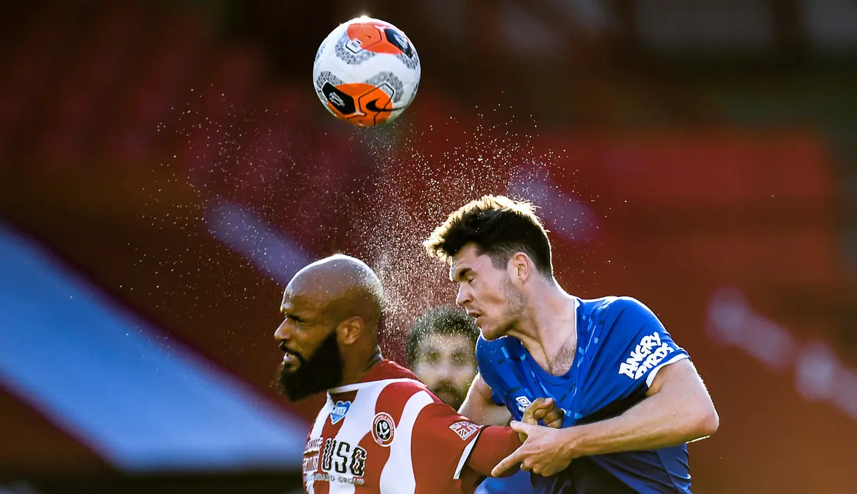 Bek Everton, Michael Keane, berebut bola dengan striker Sheffield United, David McGoldrick, pada laga lanjutan Premier League di Bramall Lane Stadium, Selasa (21/7/2020) dini hari WIB. Everton menang 1-0 atas Sheffield United. (AFP/Peter Powell/pool)