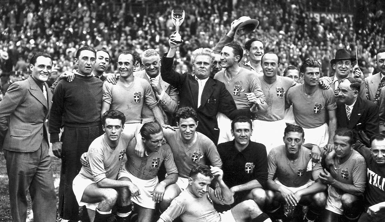 Vittorio Pozzo (tengah) ketika memegang trofi Piala Dunia 1938 setelah Italia mengalahkan Hongaria di final. Hingga saat ini, Vittorio Pozzo masih menjadi satu-satunya pelatih dengan dua gelar Piala Dunia beruntun yakni Piala Dunia 1934 dan 1938. (AFP/Staff)