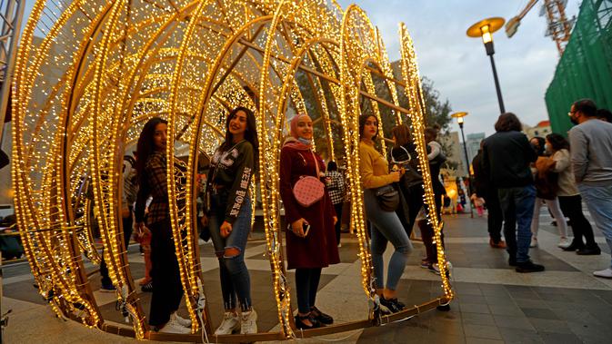 Sejumlah anak perempuan berpose dengan instalasi cahaya Natal di pusat kota Beirut, Lebanon, pada 13 Desember 2020. Baru-baru ini, berbagai dekorasi Natal telah dipasang di pusat kota Beirut menyambut liburan Natal dan Tahun Baru mendatang meski sedang dilanda pandemi COVID-19. (Xinhua/Bilal Jawich)