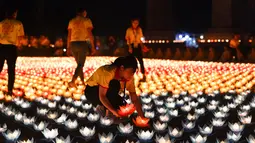 Umat Buddha meletakkan lentera saat upacara jelang perayaan Hari Waisak di Pagoda Tam Chuc, Provinsi Ha Nam, Vietnam, Senin (13/5/2019). Pagoda Tam Chuc menyelenggarakan Perayaan Besar Waisak PBB tahun 2019. (Nhac NGUYEN/AFP)