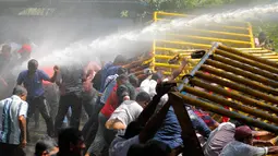 Polisi menembakkan air ke arah pendemo yang mulai rusuh saat aksi protes di dekat sekretariat presiden di Kolombo, Sri Lanka, Rabu (1/2). Pendemo menentang rencana privatisasi pelabuhan oleh pemerintah. (AP Photo / Eranga Jayawardena)