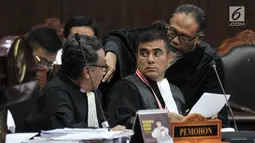 Kuasa hukum Pemohon, Bambang Widjojanto berbincang dengan kuasa hukum Pemohon lainnya saat sidang lanjutan sengketa Pilpres 2019 di Mahkamah Konstitusi, Jakarta, Rabu (19/6/2019). (merdeka.com/Iqbal S. Nugroho)