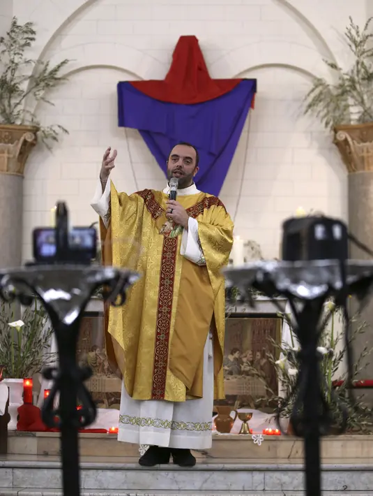Pastor Katolik Georges Nicoli memberikan khotbah saat merayakan misa Kamis Putih dengan siaran langsung melalui Facebook di gereja Notre Dame De Lourdes di Bastia, di pulau Korsika Mediterania, Prancis (9/4/2020). (AFP/Pascal Pochard-Casabianca)