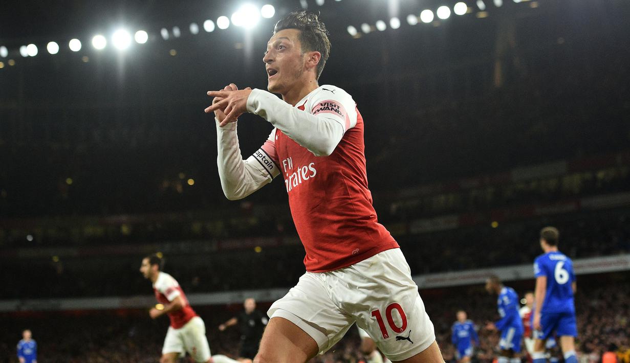 Gelandang Arsenal, Mesut Ozil, merayakan gol yang dicetaknya ke gawang Leicester pada laga Premier League Inggris di Stadion Emirates, London, Senin (22/10). Arsenal menang 3-1 atas Leicester. (AFP/Glyn Kirk)