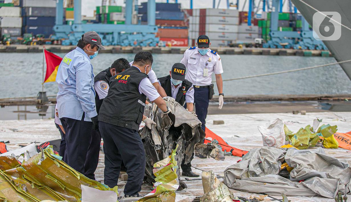 Petugas KNKT memeriksa bagian turbin pesawat Sriwijaya Air dihari kelima yang jatuh di perairan Pulau Seribu, di Dermaga JICT, Jakarta,  Rabu (13/1/2021). Potongan mesin jenis pesawat Boeing 737-500 yang ditemukan di perairan Kepulauan Seribu. (Liputan6.com/Faizal Fanani)