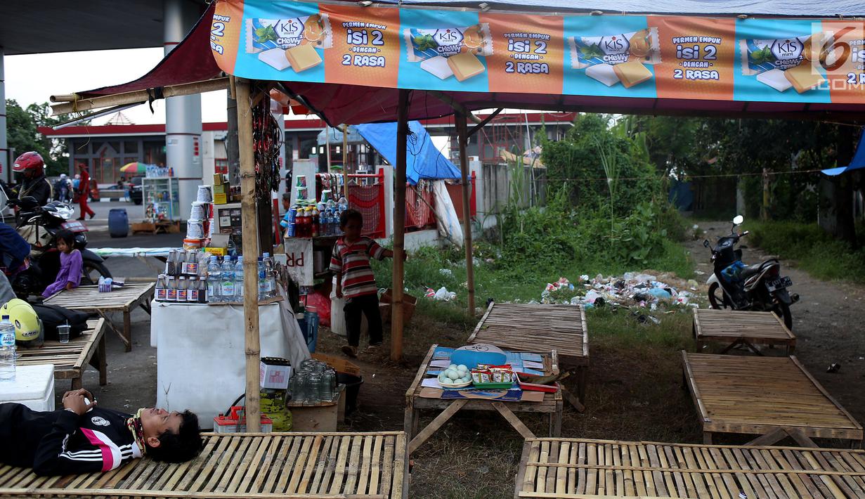 Warga berjaga di warung tidak permanen di SPBU, Jalur Pantura, Cirebon, Jawa Barat, Rabu (21/6). Menjelang puncak arus mudik Lebaran 2017, warga yang tinggal di dekat jalur Pantura membuat warung-warung dadakan. (Liputan6.com/Johan Tallo)