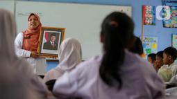 Bersama para murid, pengajar dan staff administrasi Sekolah Dasar Negeri (SDN) Pondok Labu 14 Jakarta mengganti foto Presiden dan Wakil Presiden yang terpasang di dinding ruang kelas. (Liputan6.com/Herman Zakharia)
